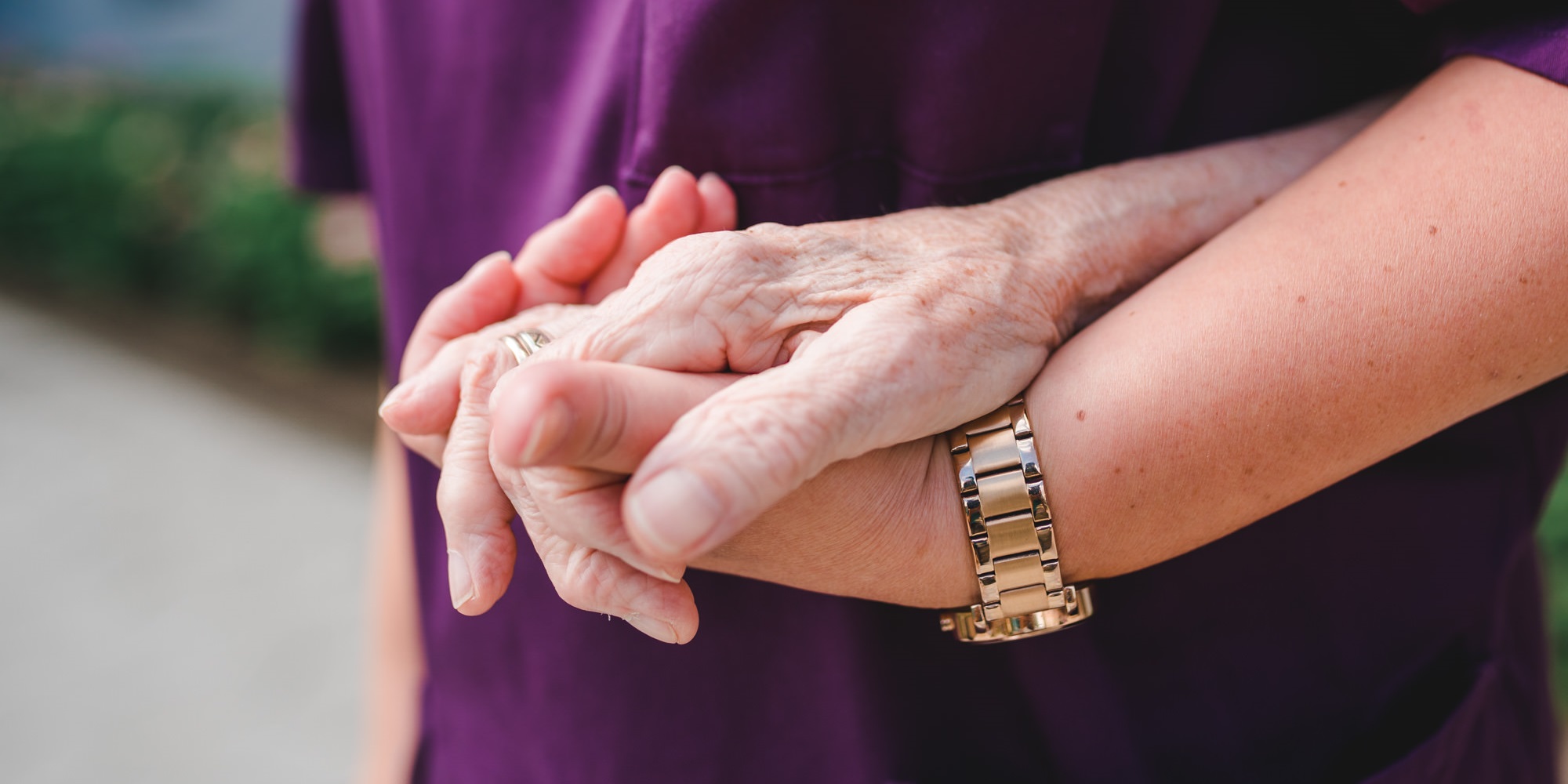 Hand eines Bewohners hält die Hand einer Pflegekraft fest