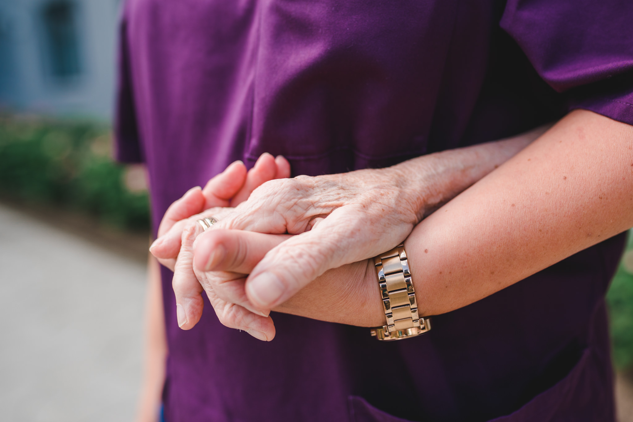 Hand eines Bewohners hält die Hand einer Pflegekraft fest