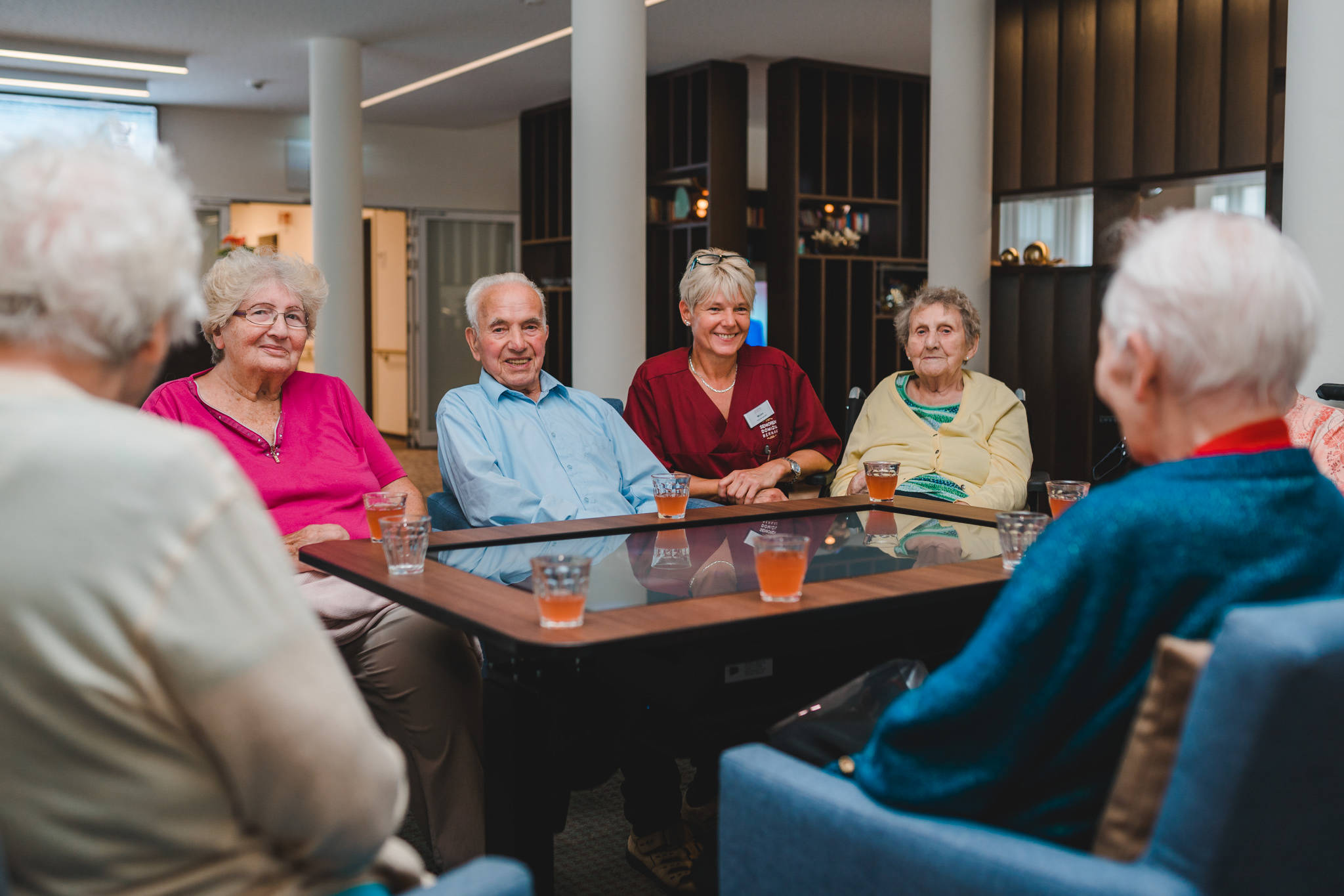 Gruppe von Bewohnern am Tisch sitzend und lachend